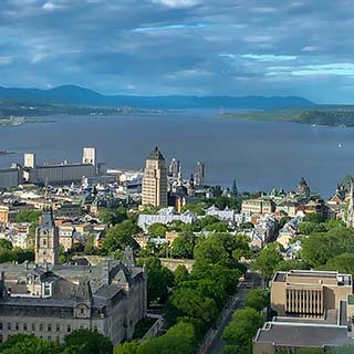 Vue de haut sur le château Frontenac et le parlement de Québec, avec en fond le fleuve Saint-Laurent